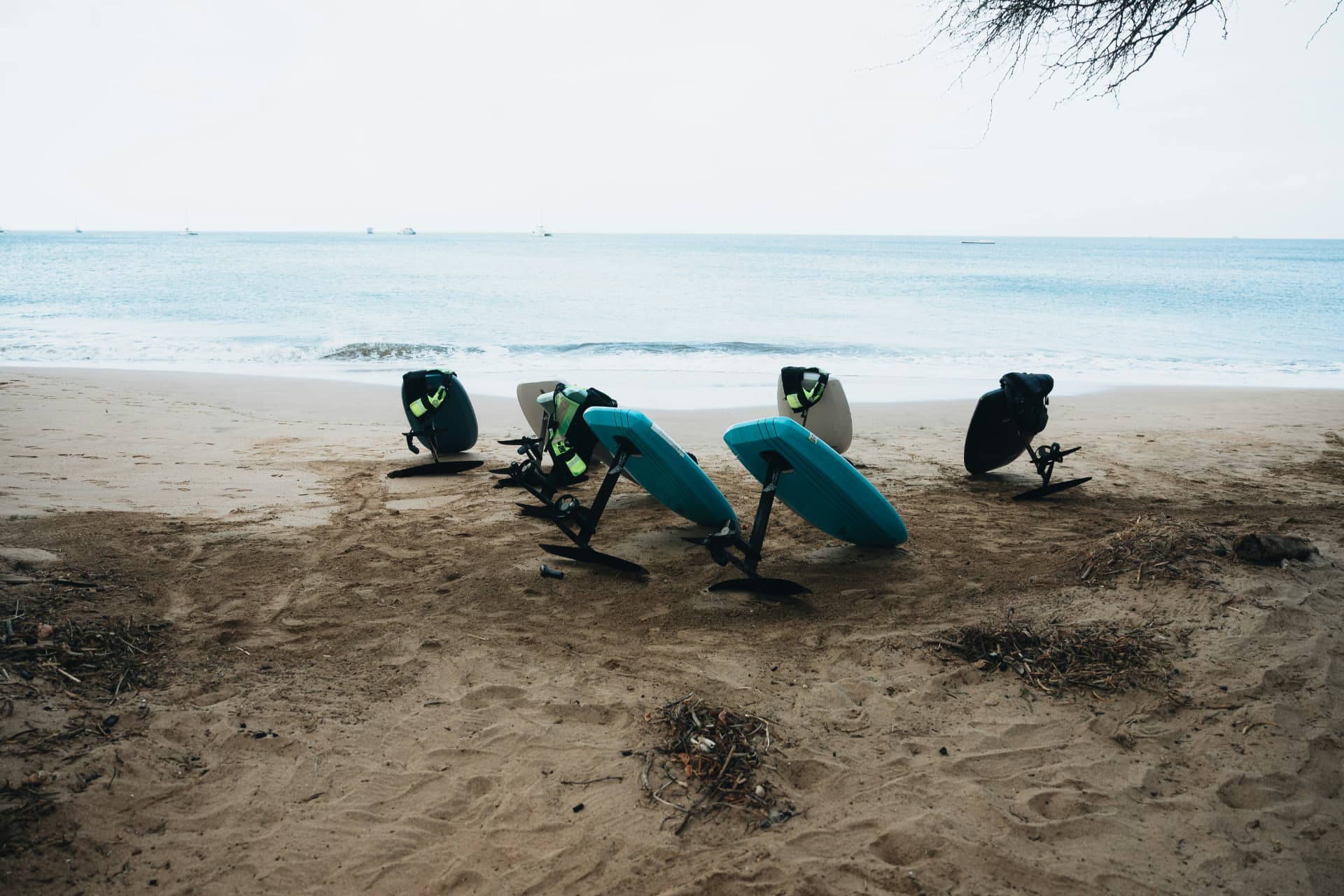 Electric foil boards lined up on a UK beach at low tide