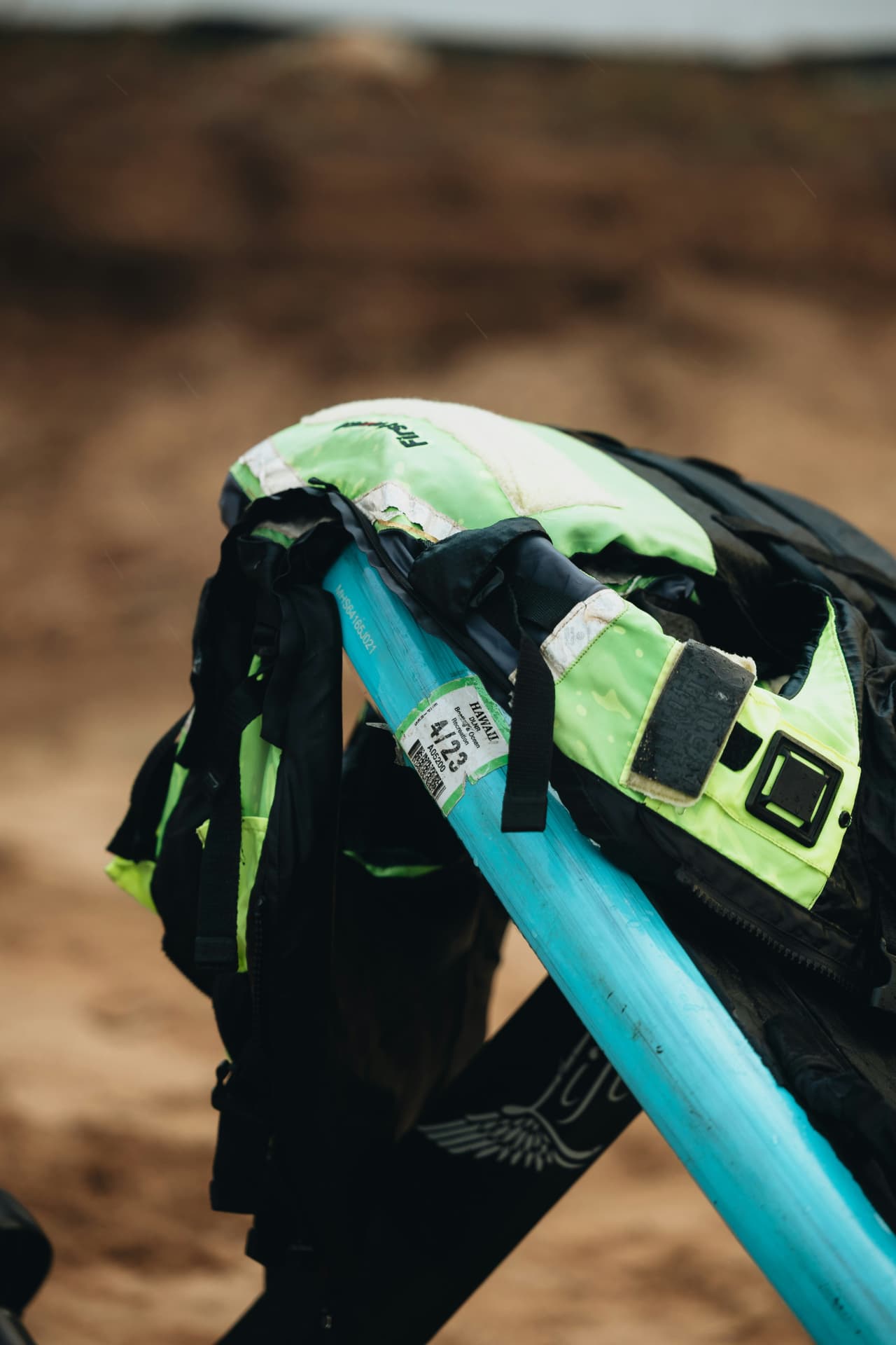 A buoyancy aid and safety kit resting on a foil board on the beach